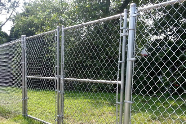 Galvanized chain link fence with a double swing gate installed for secure residential, commercial, and industrial property access.