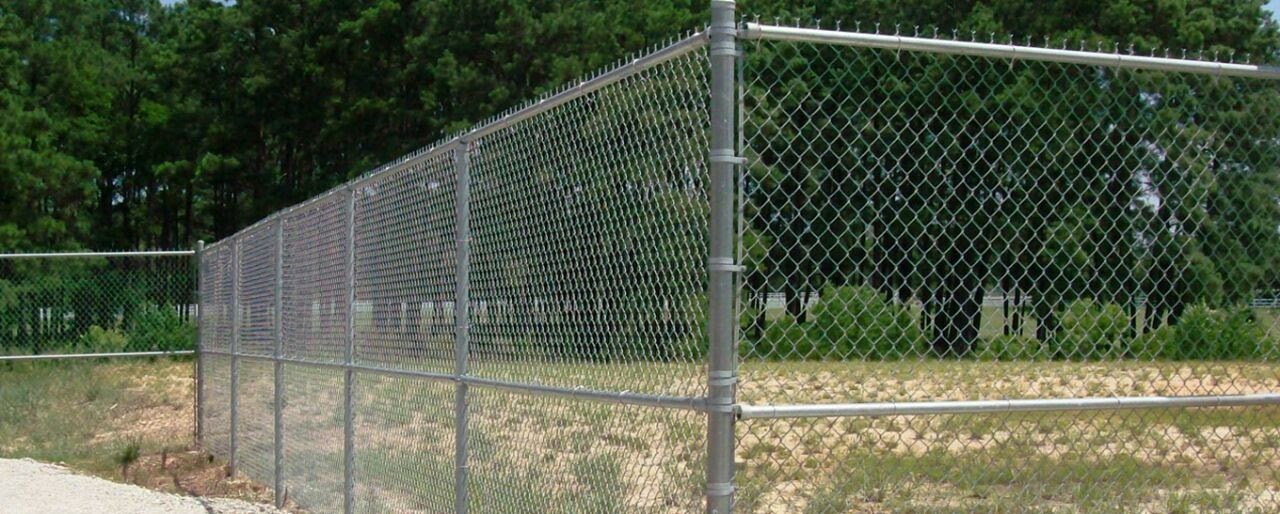 Heavy-duty galvanized chain link fence with top rail installed for secure industrial and commercial perimeter protection.