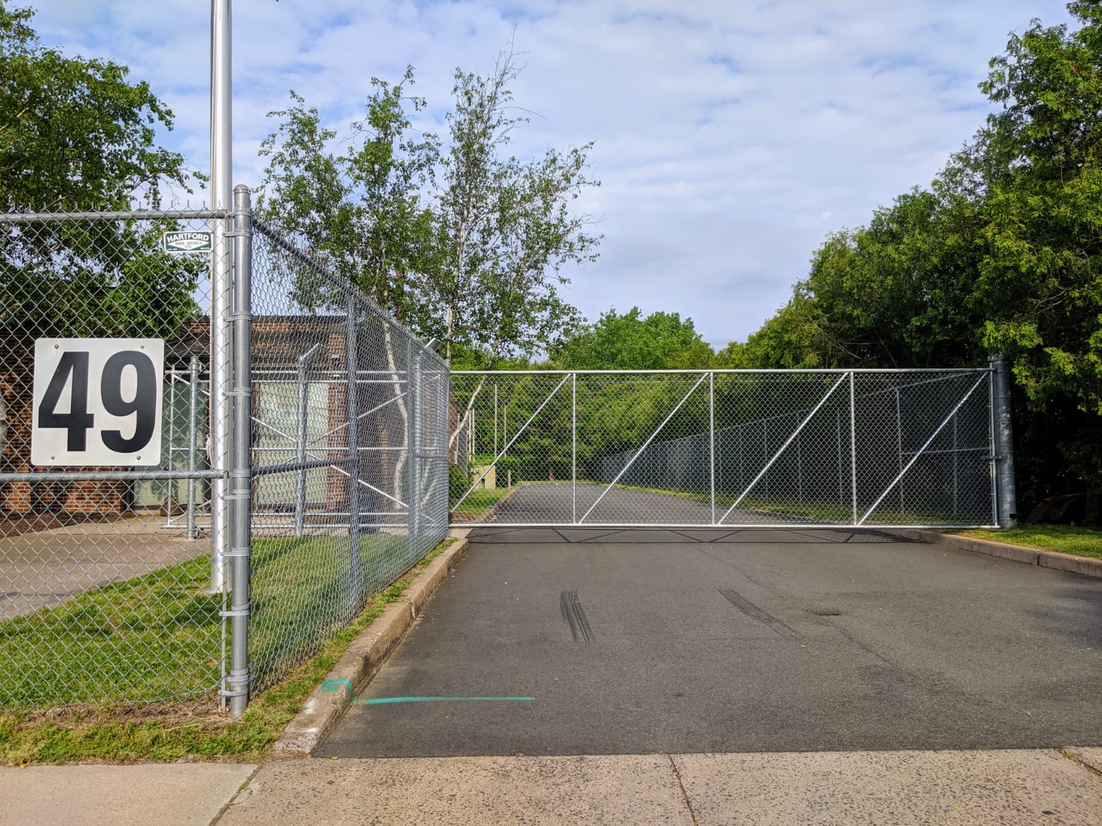 Heavy-duty galvanized sliding chain link security gate installed at a commercial facility for controlled vehicle access and perimeter protection.