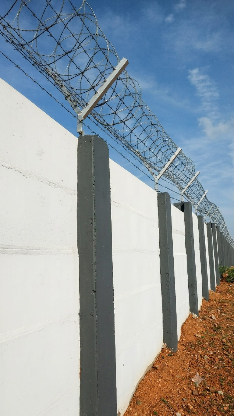 480 mm galvanized concertina razor wire installed on a concrete compound wall for high-security perimeter protection.
