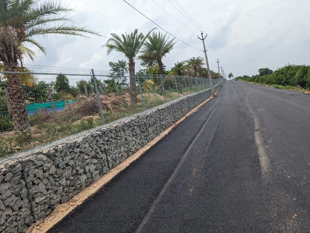 Galvanized welded mesh boundary fence installed on a gabion retaining wall for secure property perimeter protection.